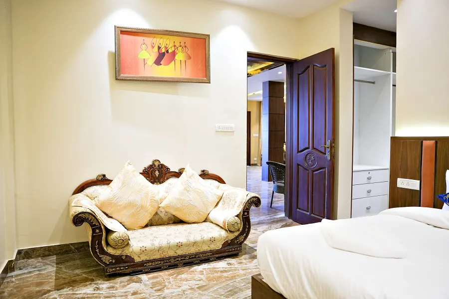 Bedroom with a carved chaise longue at the foot of the bed and a wardrobe alongside